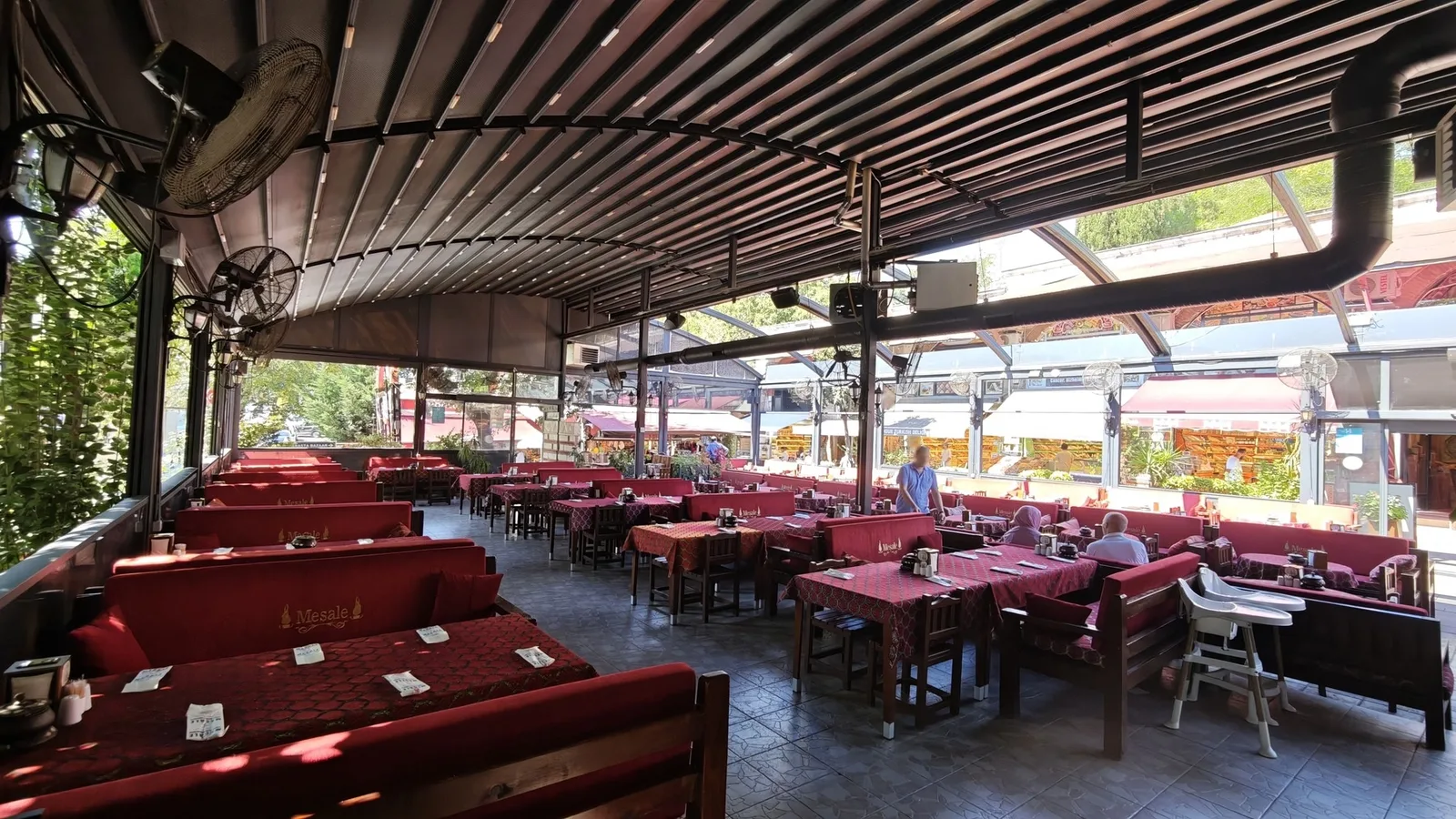 Bahçedeki sahne alanı ve çevresine kurulmuş masalar